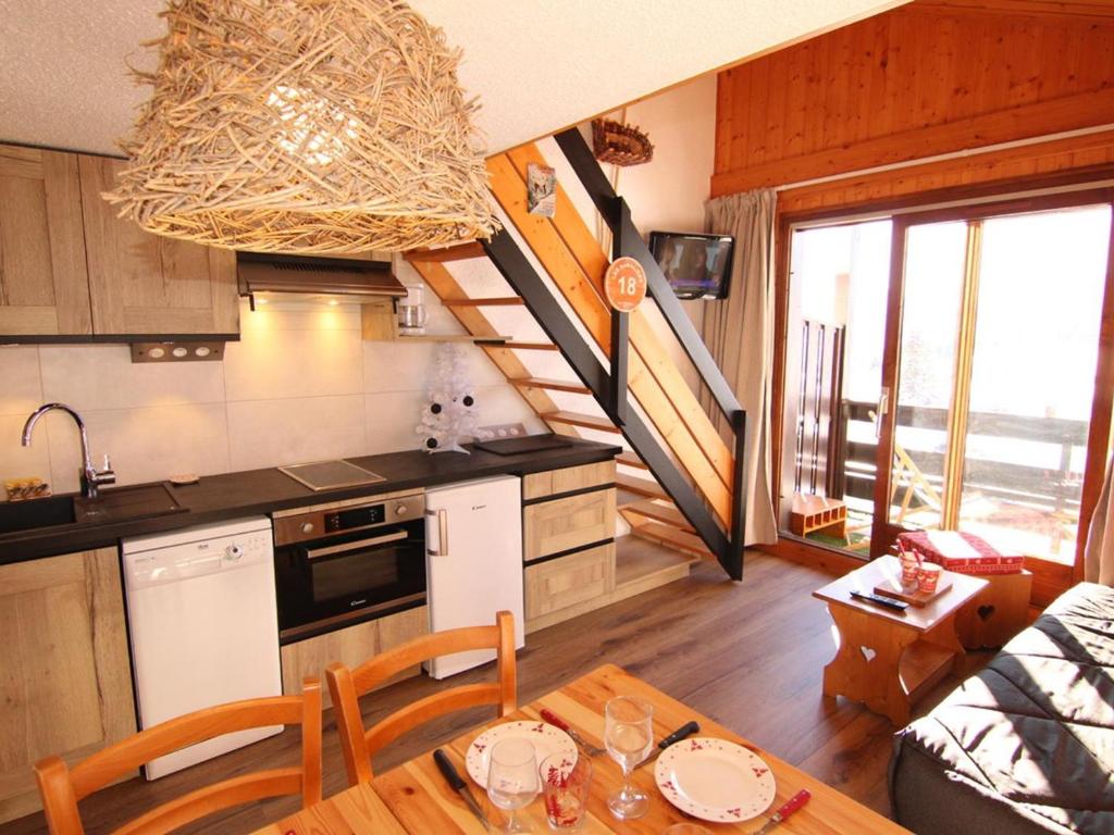 Il comprend une cuisine et un salon avec une table et un escalier. dans l'établissement Studio cabine Les Saisies 6 pers, proche pistes, balcon sud/est - FR-1-594-188, à Hauteluce