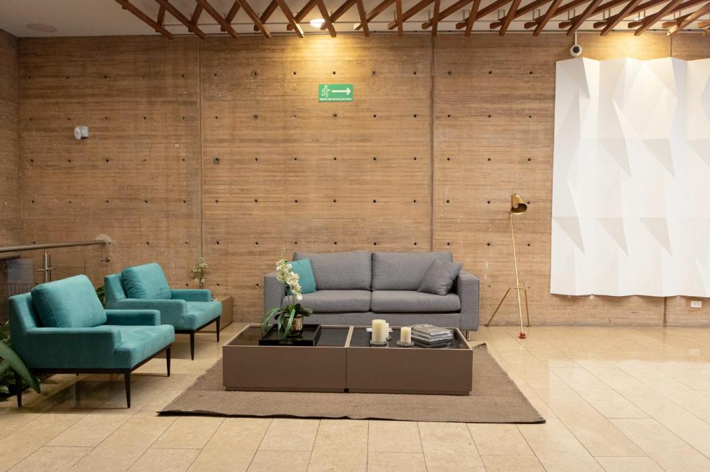 a living room with a couch and two chairs and a table at The Equilibrium Collection in Centro Internacional in Bogotá