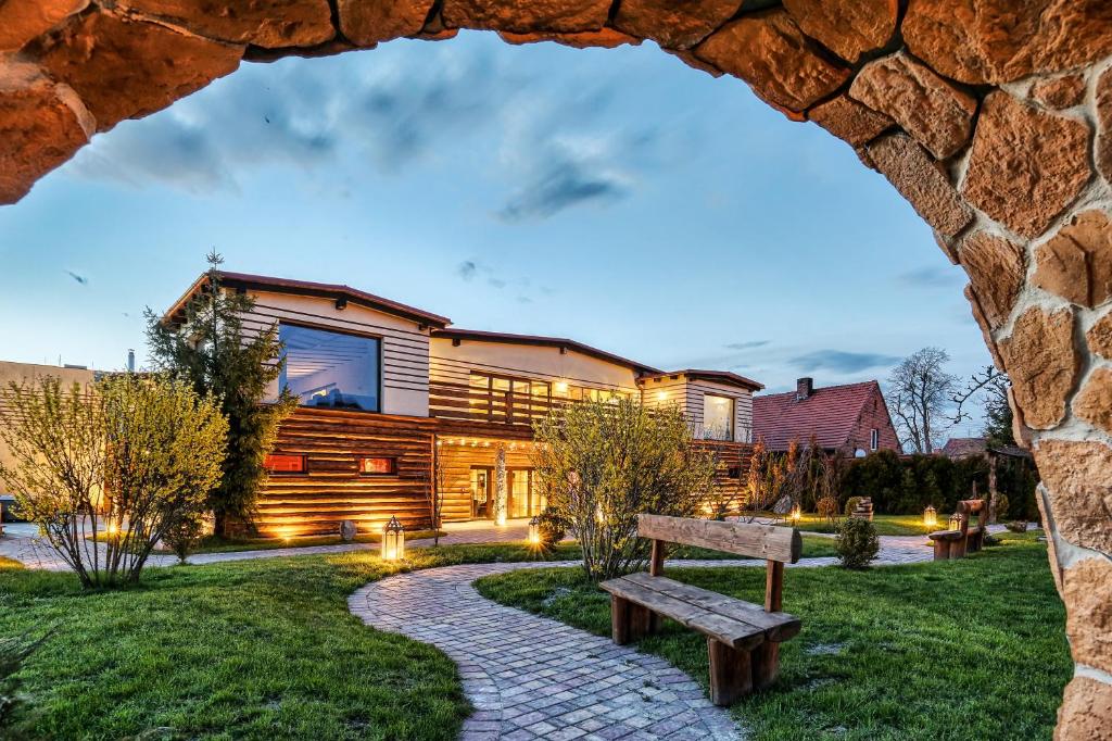 a house with a stone pathway and a bench at Sommer Residence Hotel&Spa in Kluczbork