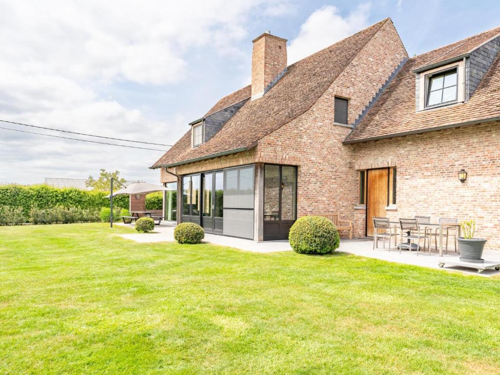 een uitzicht op een bakstenen huis met een gazon bij Villa Meersen in Maldegem