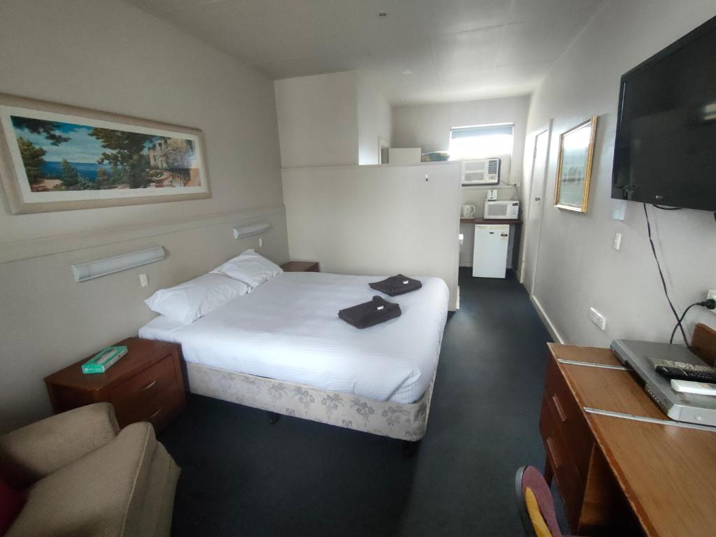 Habitación de hotel con cama y TV en International Hotel Motel en Port Pirie