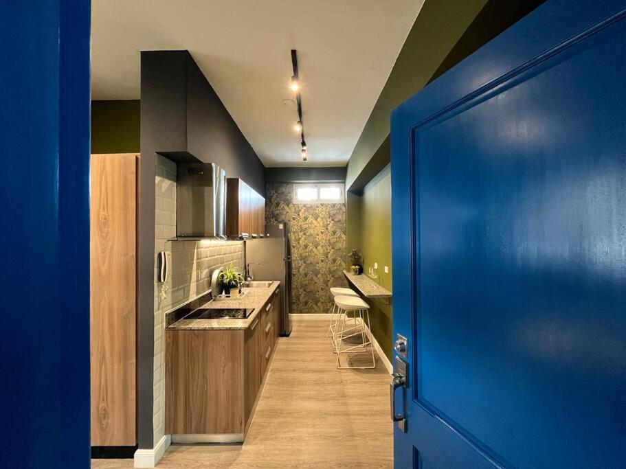 een keuken met een blauwe deur en een keuken met een wastafel bij 01 Modern aparment Panama! Ubicación perfecta pty in Panama-Stad