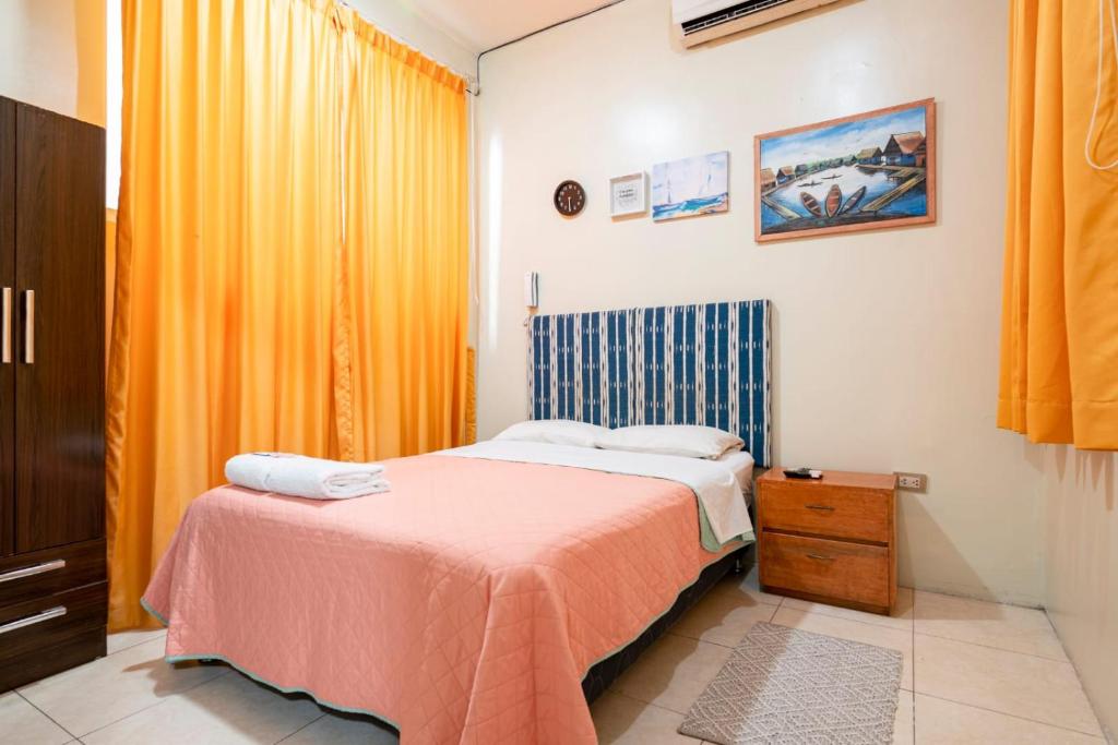 a bedroom with a bed with a pink blanket at 203 RV Apartments Iquitos-Apartamento con dos habitaciones in Iquitos