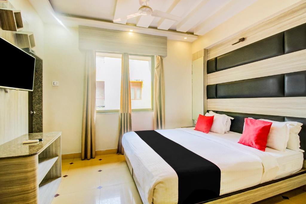 a bedroom with a large bed with red pillows at Collection O 30965 Baga Residency in Baga
