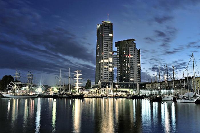 a harbor with boats in the water at night at MW Apartamenty - Sea Towers in Gdynia