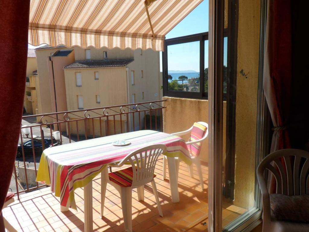 une table et des chaises sur un balcon avec vue dans l'établissement Studio Mezzanine proche plage avec terrasse et parking - Bormes-les-Mimosas - FR-1-610-45, à Bormes-les-Mimosas