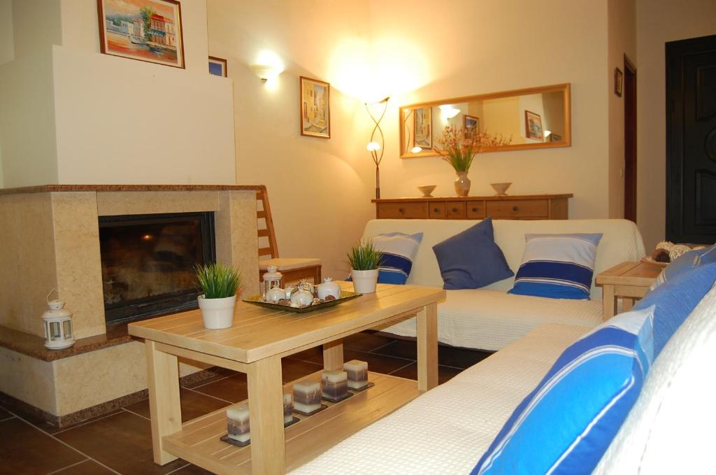 a living room with a couch and a fireplace at Chris and Nick Corfu Villa in Korakádes