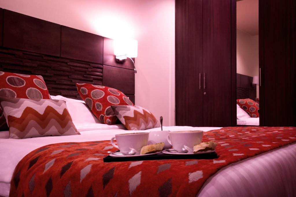 Postel nebo postele na pokoji v ubytování Bidwood Suite Hotel