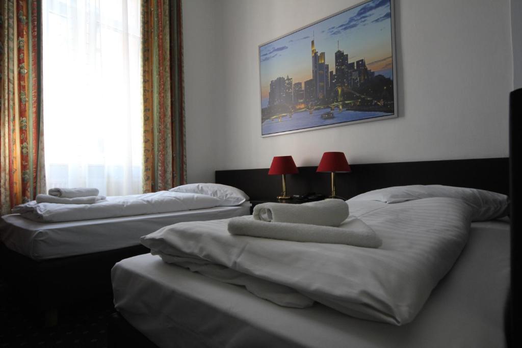 a group of three beds in a room at Carlton Hotel in Frankfurt