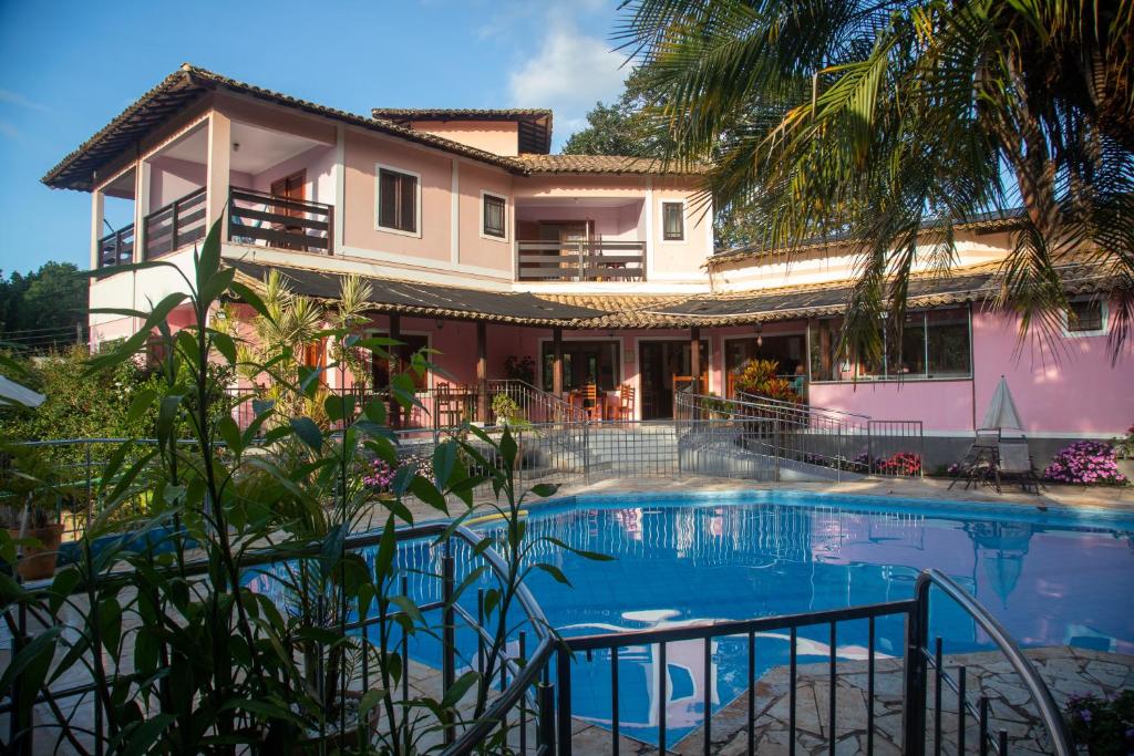 uma casa com piscina em frente a uma casa em Pousada Casa Rosa em Alto Paraíso de Goiás