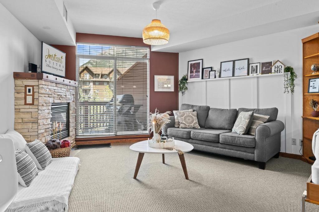 a living room with a couch and a fireplace at ⭐️ Luxury Mountain View Studio in Canmore ⭐️ in Canmore