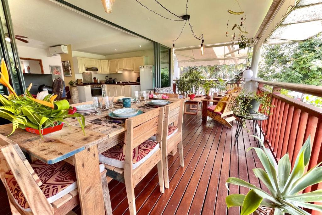 cocina y comedor con mesa en la terraza en Vaiava Beach Carlton- Tahiti - beachfront luxury residence & pool - 4 pers en Punaauia