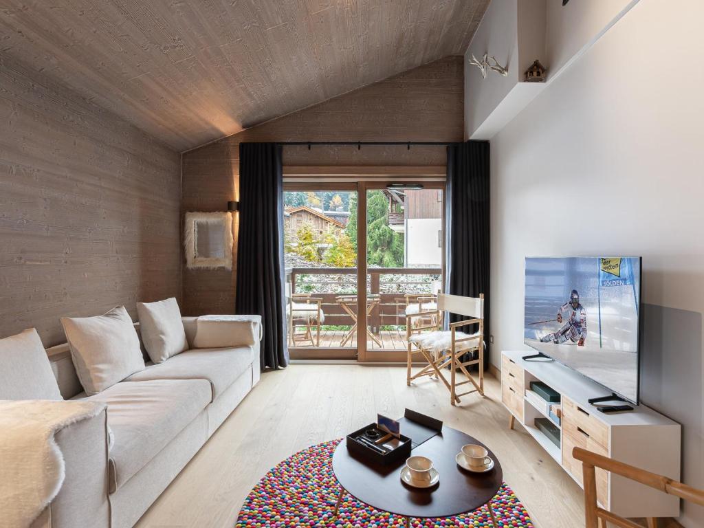 un salon avec un canapé et une télévision dans l'établissement Charmant Appartement à Rochebrune, Megève - Résidence avec Piscine, Sauna, Hammam et Salle de Sport - FR-1-569-30, à Megève