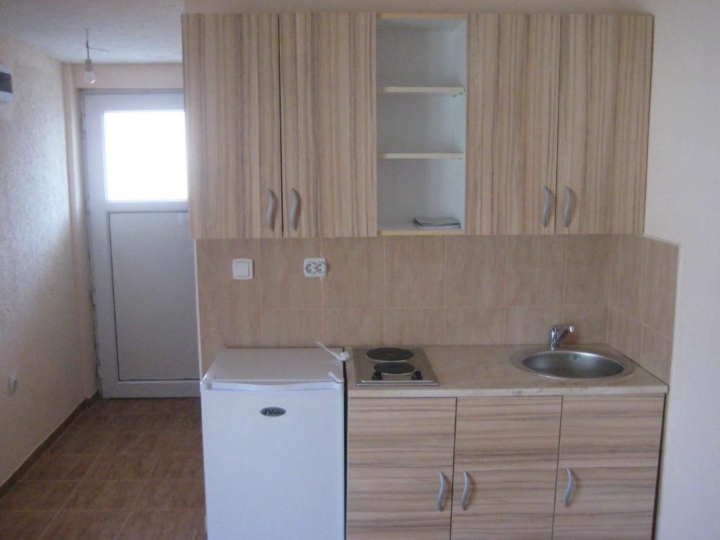 a small kitchen with a sink and a refrigerator at Apartmani Ksenija in Bar