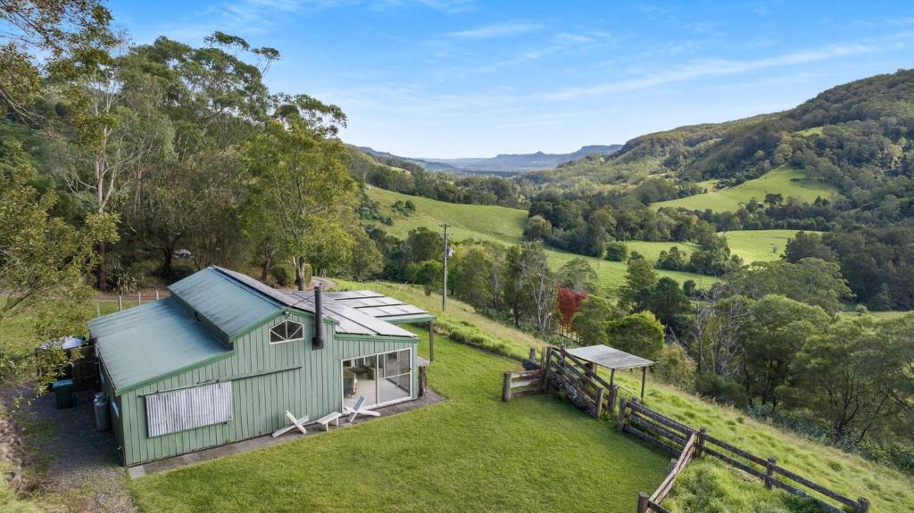 una vista aérea de una cabaña verde en las colinas en Molla Eco Lodge, en Wattamolla