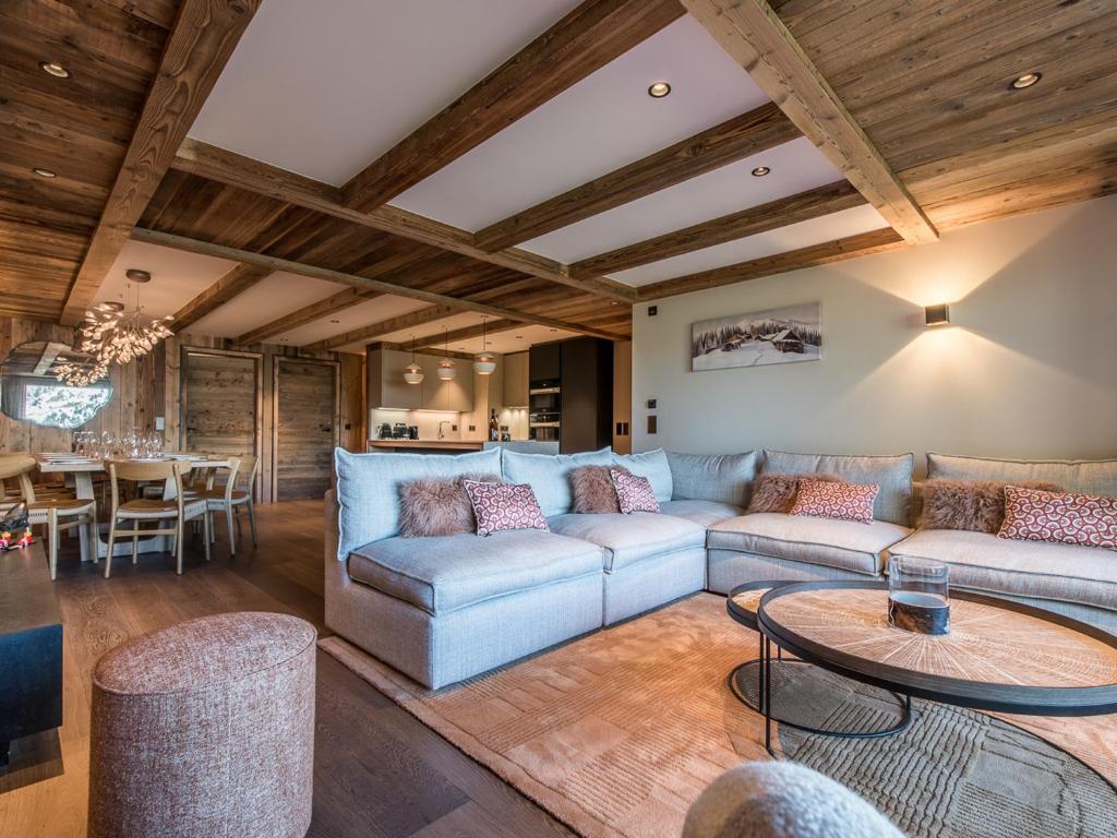 un salon avec un canapé et une table dans l'établissement Appartement Luxueux avec Spa, Parking & Wi-Fi à Méribel - FR-1-613-60, à Les Allues