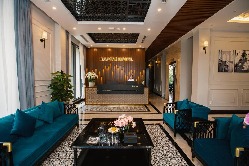 a living room with blue couches and a stage at Napoli Hotel in An Khê