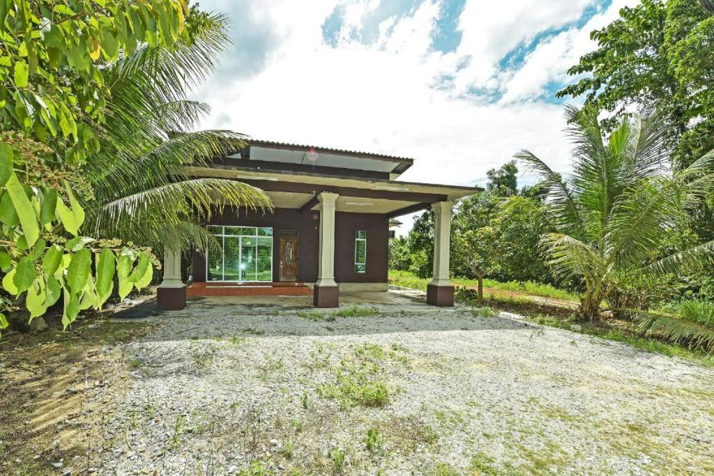 a small house with a gravel driveway in front of it at Casaria Homestay Besut in Jertih