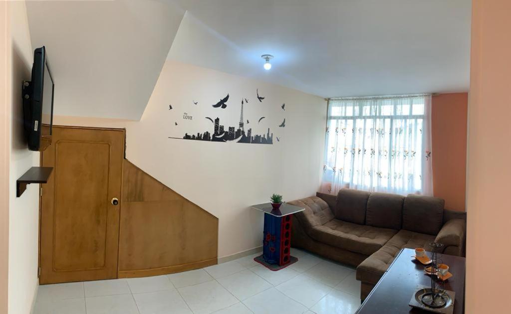 sala de estar con sofá y escalera en Hermoso Alojamiento, en Choachí