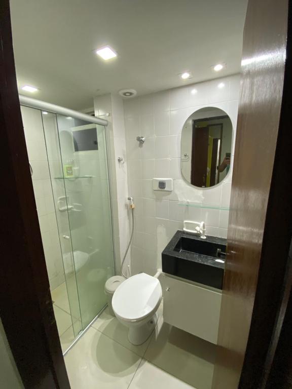 y baño con aseo, lavabo y espejo. en Pousada Atlântico tambaú Flat, en João Pessoa