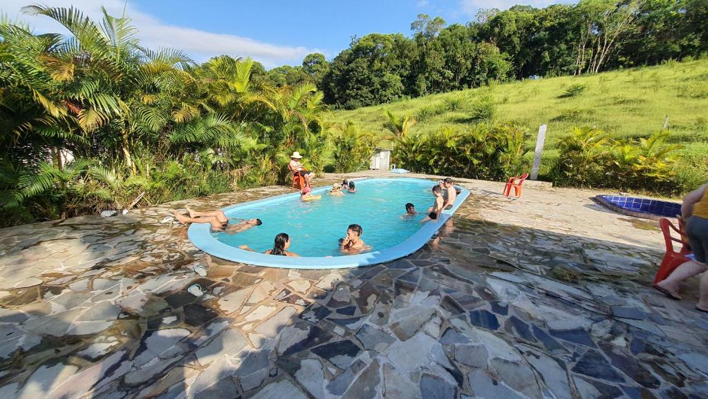 a group of people in a swimming pool at RECANTO NA MATA in Morretes