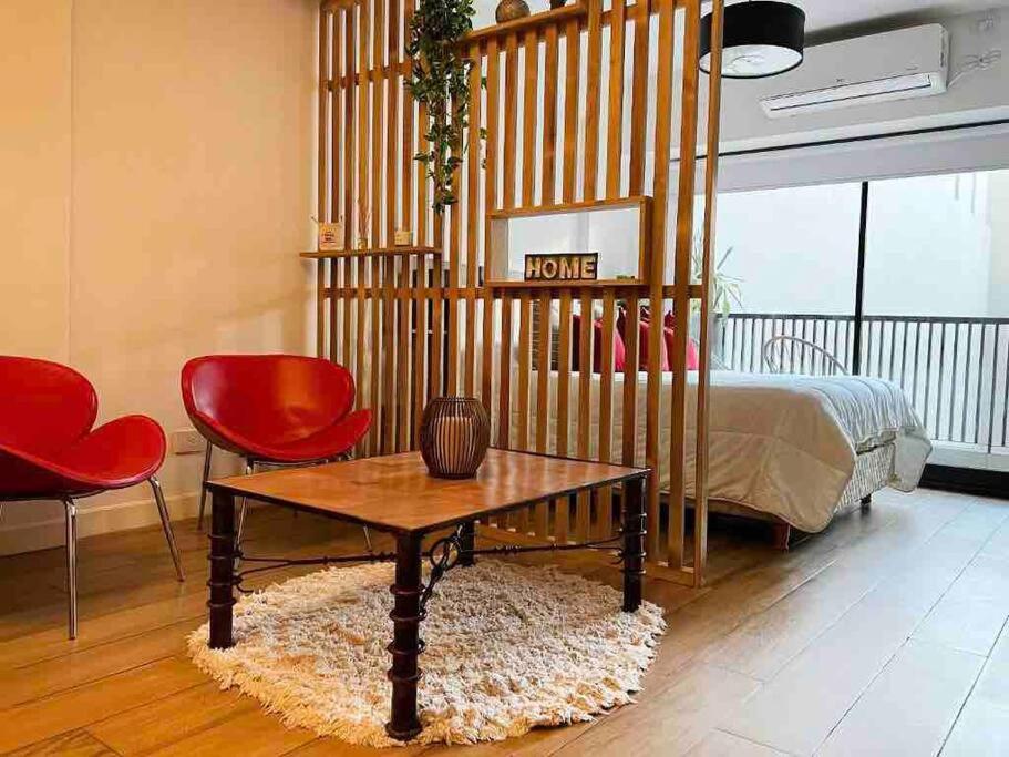 1 dormitorio con 1 cama, mesa y sillas en Estudio en Palermo con balcon y edificio con amenities en Buenos Aires