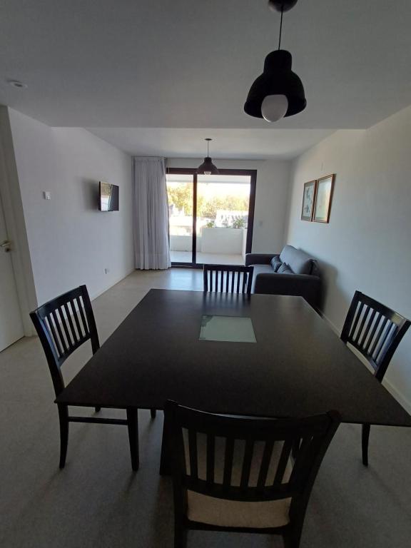 uma sala de estar com uma mesa de jantar e cadeiras em Apart Playa Grande em Mar del Plata