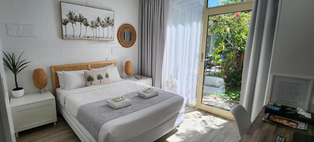 a bedroom with a bed with two towels on it at Peninsula Beach Motel in Rosebud