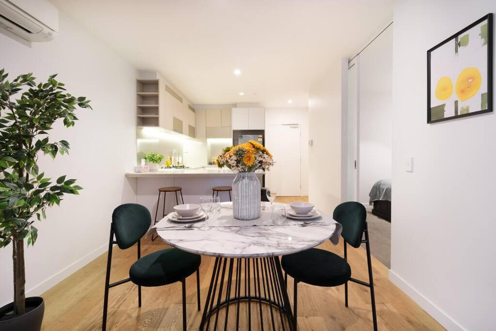 una sala da pranzo e una cucina con tavolo e sedie di Stylish CBD apt in prime location w Balcony#TF2508 a Melbourne