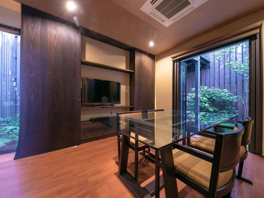 a dining room with a glass table and a television at Tsuruya / Vacation STAY 59052 in Miyaji
