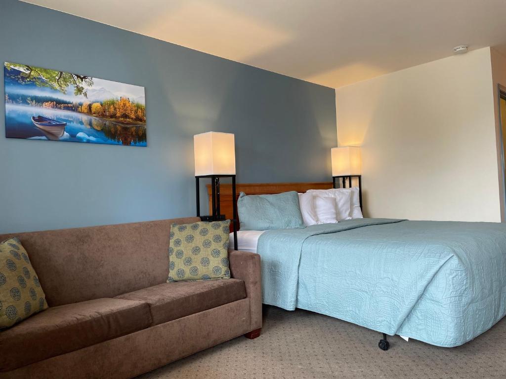 a hotel room with a bed and a couch at White Rose Inns & Motel in Wisconsin Dells