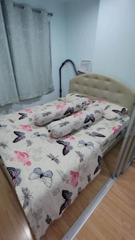 a bed with butterfly pillows on top of it at Lumpini Prachachaeun Great condo near Lumpini Park in Ban Bang Khen (1)