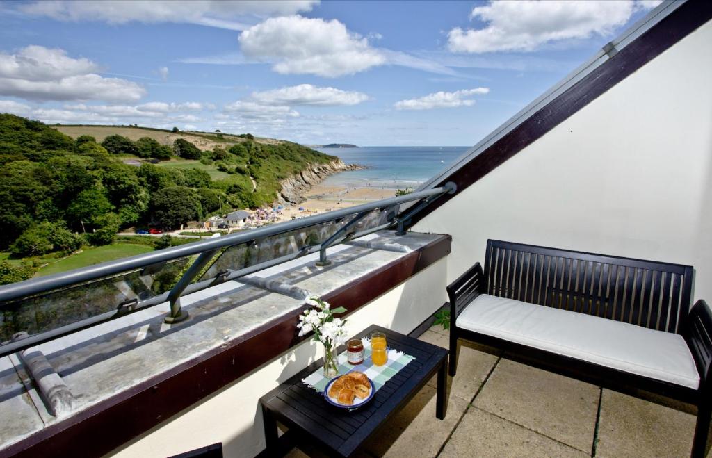 a balcony with a table with a plate of food at The Crows Nest in Falmouth