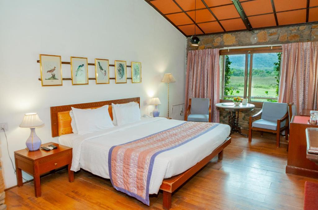 1 dormitorio con 1 cama grande, mesa y sillas en Shikarbadi Hotel - Heritage by HRH Group of Hotels, en Udaipur