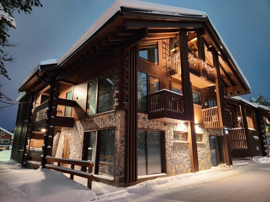 une cabane en rondins dans la neige avec un balcon dans l'établissement Levi Platinum Superior Apartments, à Levi