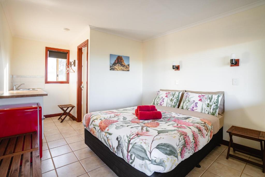 Un dormitorio con una cama con una almohada roja. en Cheela Plains Station Stay, en Tom Price