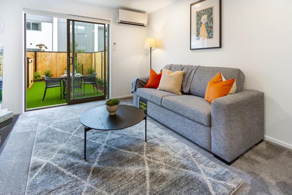 a living room with a couch and a table at The Tranquil Terrace - Zen zone 2 bed 2 bath in Christchurch