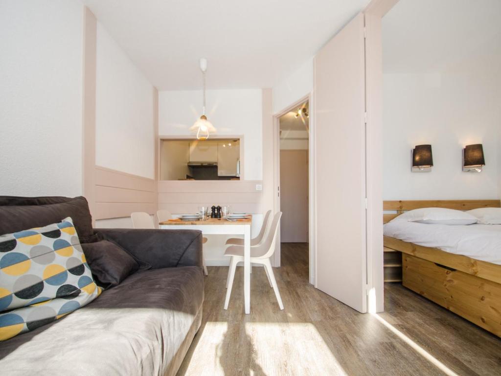 - un salon avec un canapé, un lit et un bureau dans l'établissement Joli appartement à Chamonix avec balcon, WiFi et animaux acceptés - FR-1-343-157, à Chamonix-Mont-Blanc