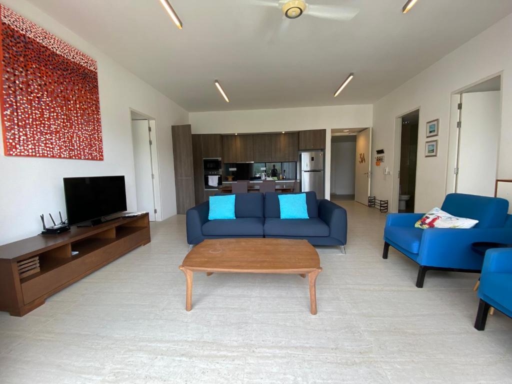 峇都丁宜的住宿－By The Sea - UBTS SMART ENTERPRISE，客厅配有蓝色的沙发和桌子