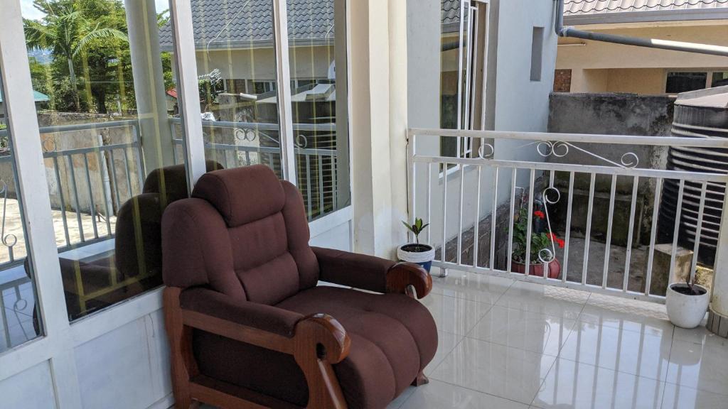 Rubavu的住宿－Ignite guest and apartment，坐在门廊上的棕色摇椅