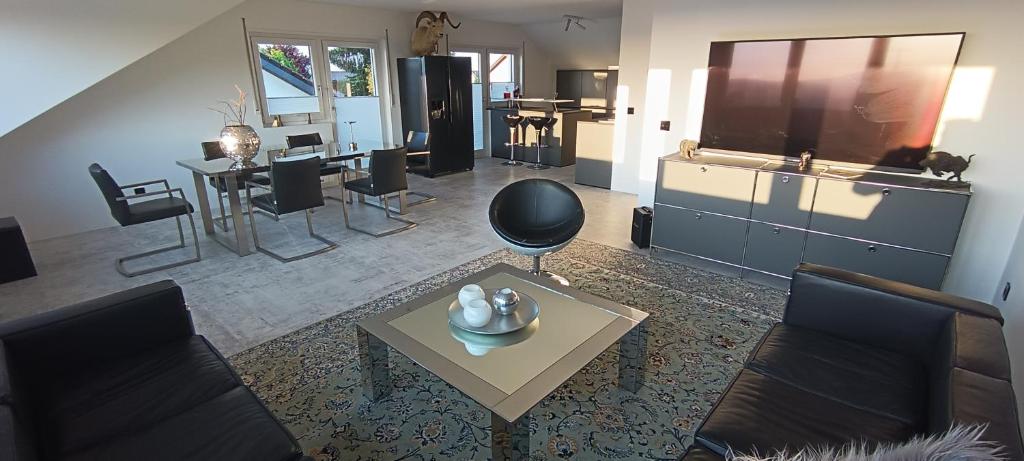 een woonkamer met een tv en een tafel en stoelen bij Heidelberg Living in Leimen