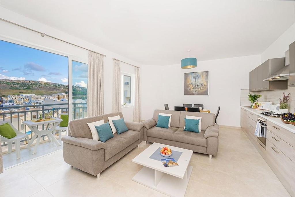 a living room with a couch and a table at Hillock Residence Apartments in Marsalforn