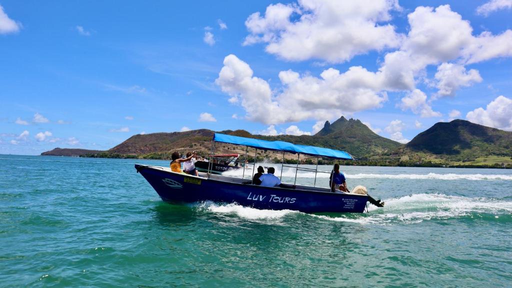 a group of people on a blue boat in the water at LUV TOURS in Centre de Flacq