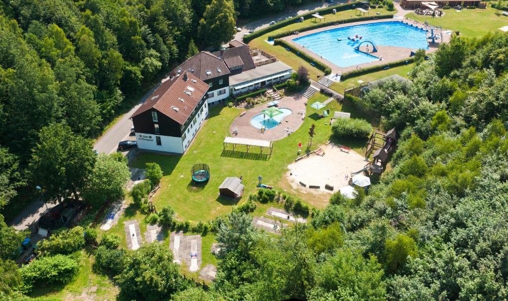 eine Luftansicht eines Hauses mit Pool in der Unterkunft Hotel Im Tannengrund in Langelsheim