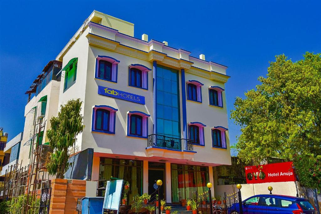 un edificio con una macchina blu parcheggiata di fronte di FabExpress Anuja a Jaipur