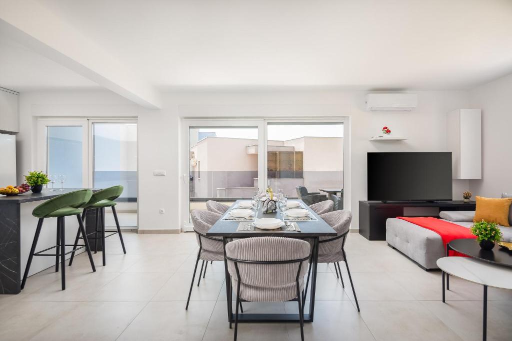 een woonkamer met een tafel en stoelen en een bank bij Lucas - Sea view apartment with parking in Makarska