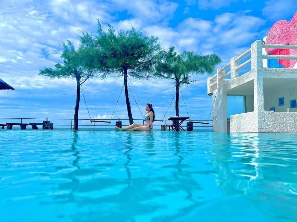 a woman sitting in the middle of a swimming pool at Hai Yen Family Hotel in Mui Ne