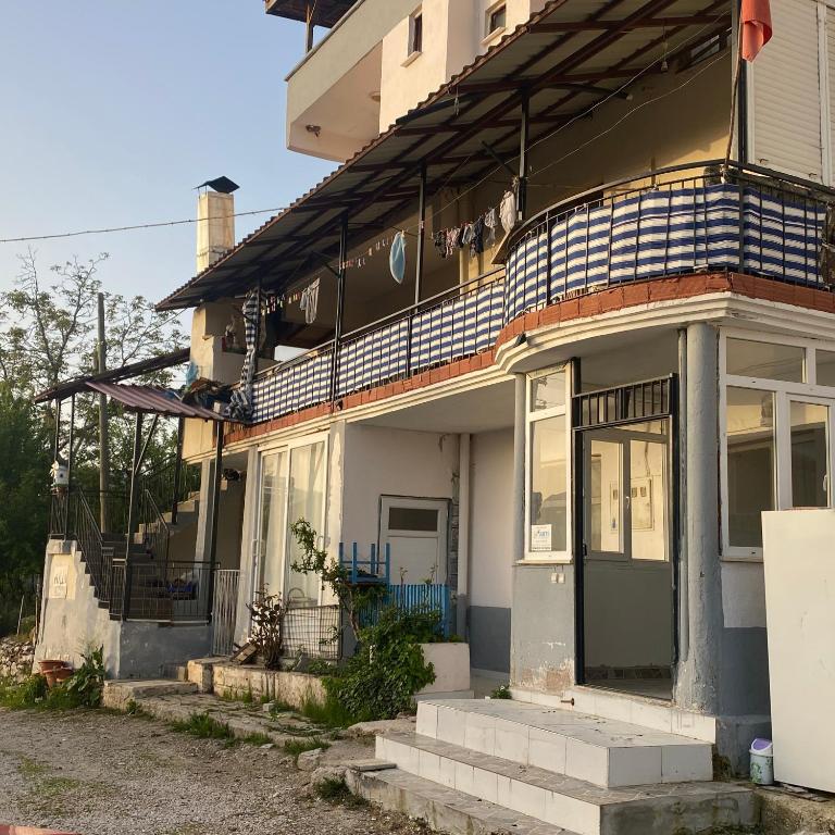 Cette maison ancienne dispose d'une terrasse couverte et d'une porte. dans l'établissement Akın pansiyon, à Gömbe