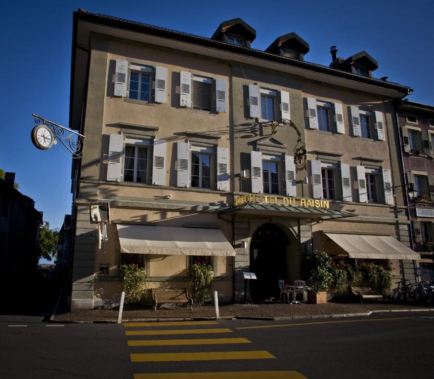 un bâtiment avec une horloge sur son côté dans l'établissement Auberge du Raisin, à Cully