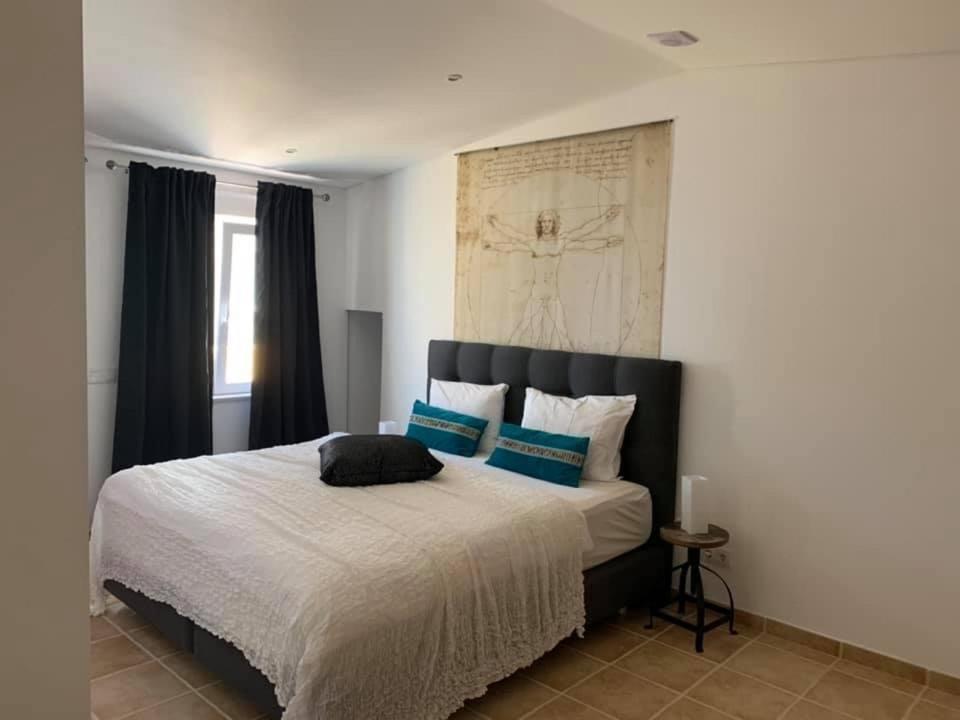 1 dormitorio con 1 cama grande con almohadas azules en La petite maison, en Portimão